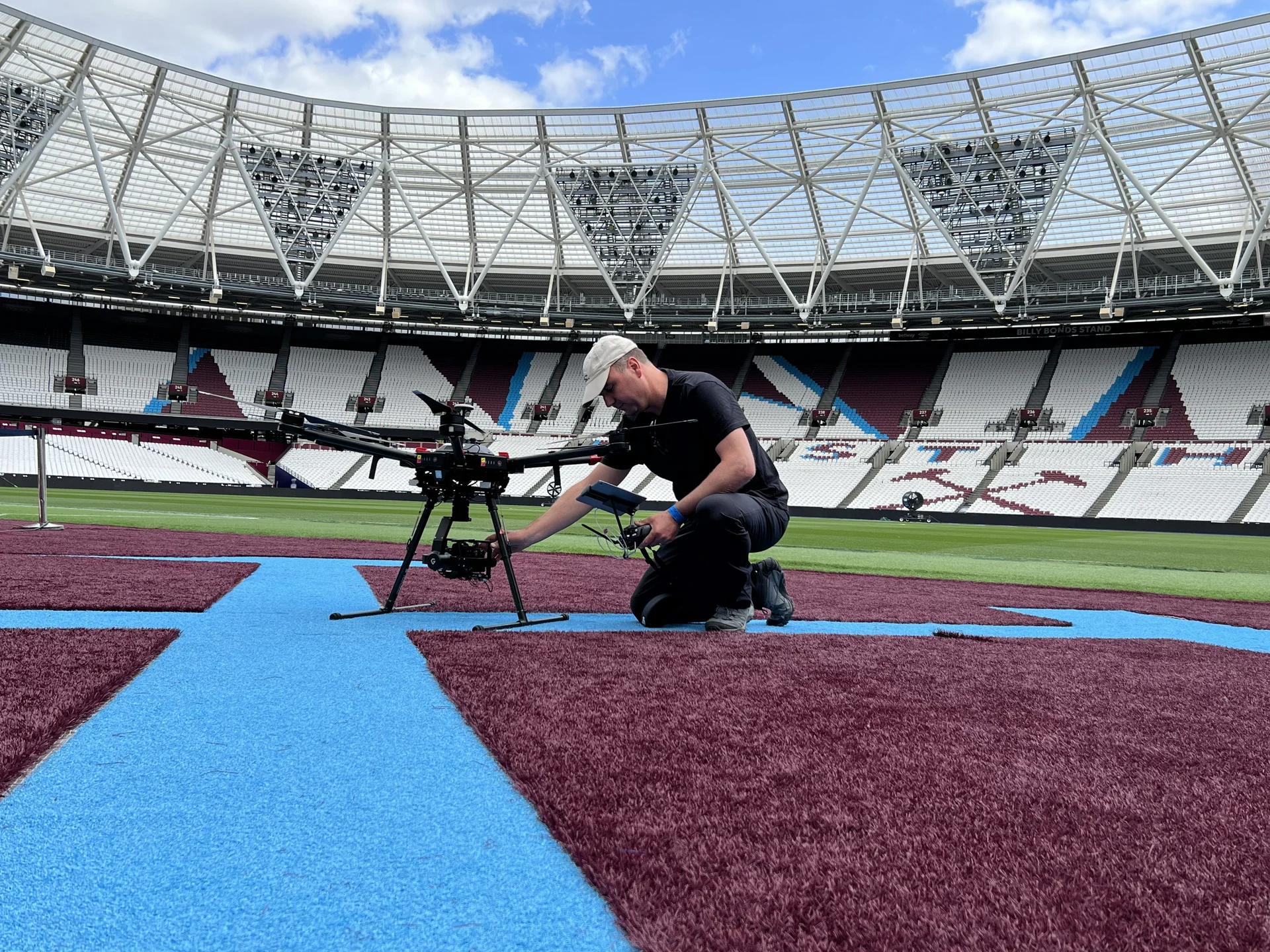 Drone operator preparing a survey drone on the pitch at London Stadium