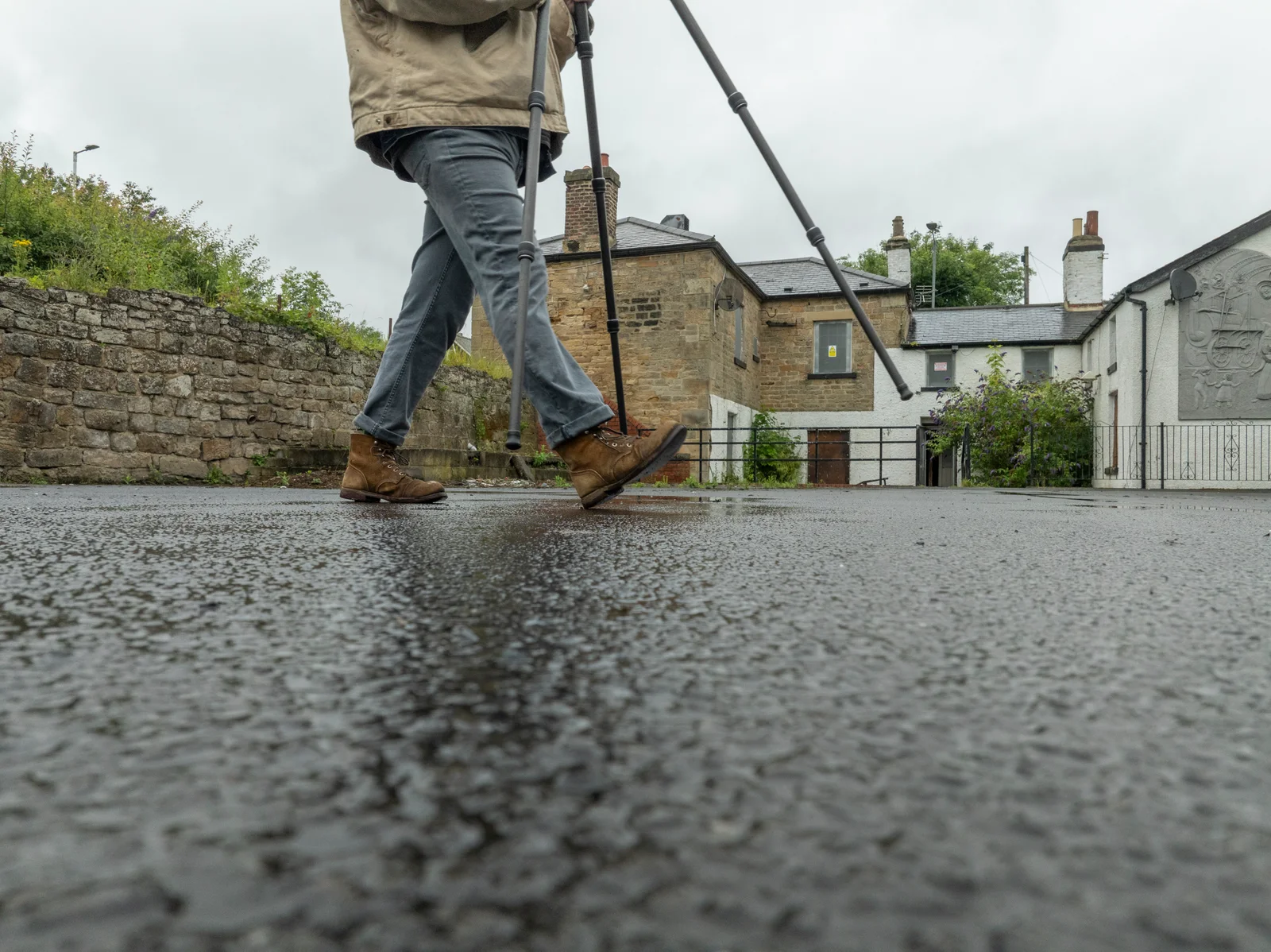 Walking a scanning target across the wet forecourt outside the station