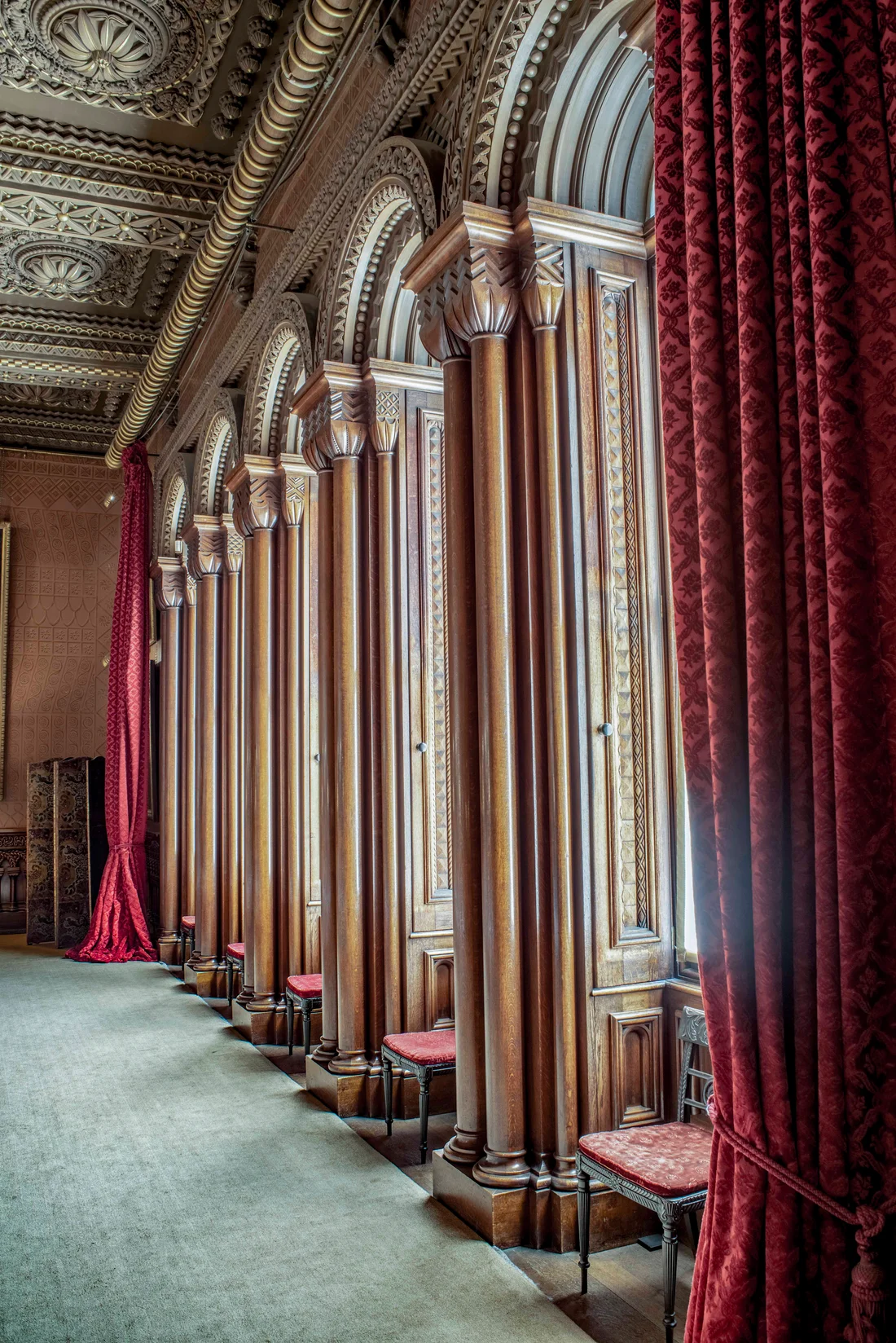 The red drawing room with its curtains and carved columns