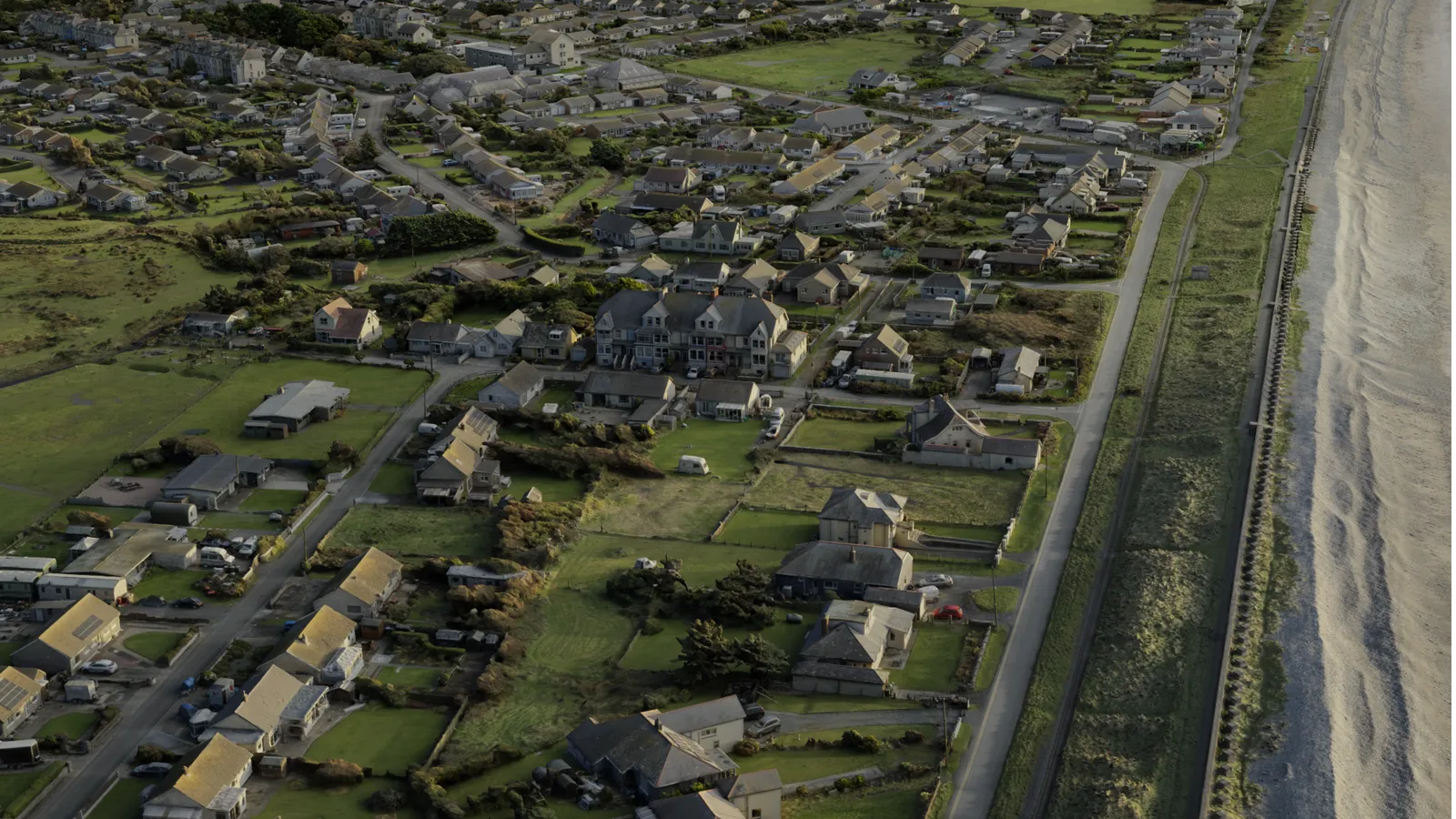 Photoreal 3D render of Fairbourne village from the air with the Welsh coast