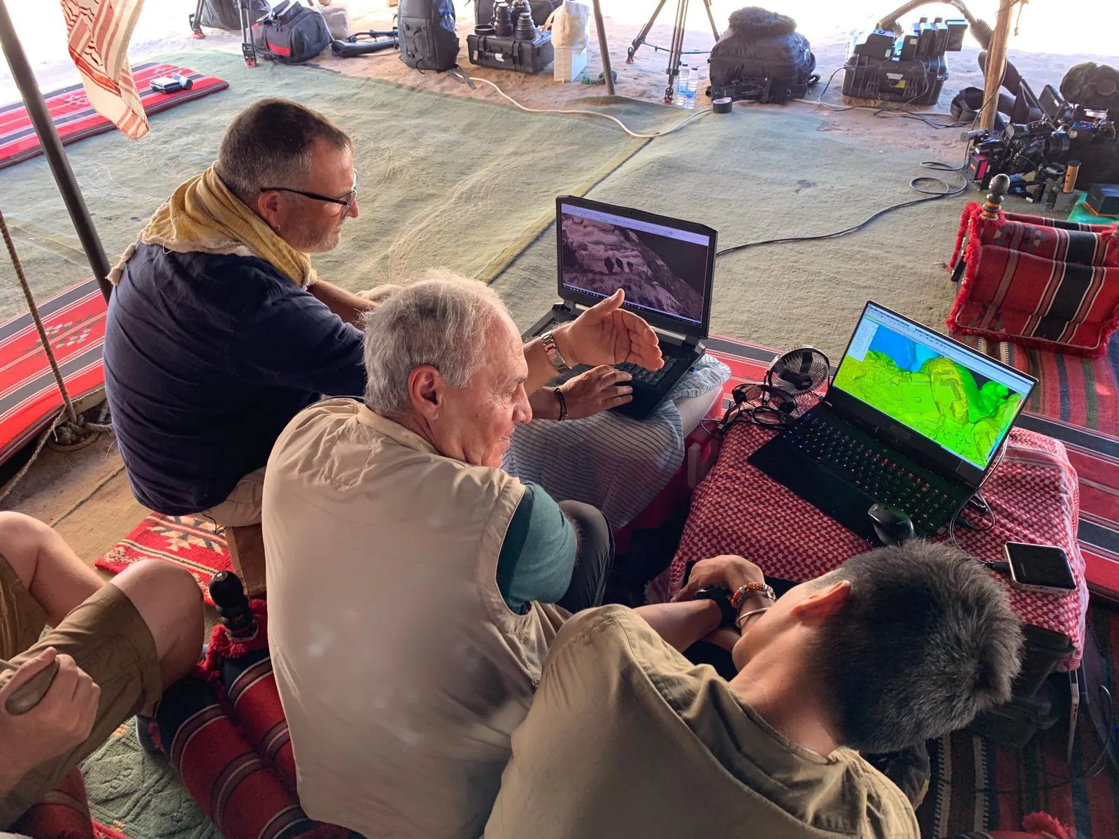 Team reviewing 3D scan data on laptops in the field